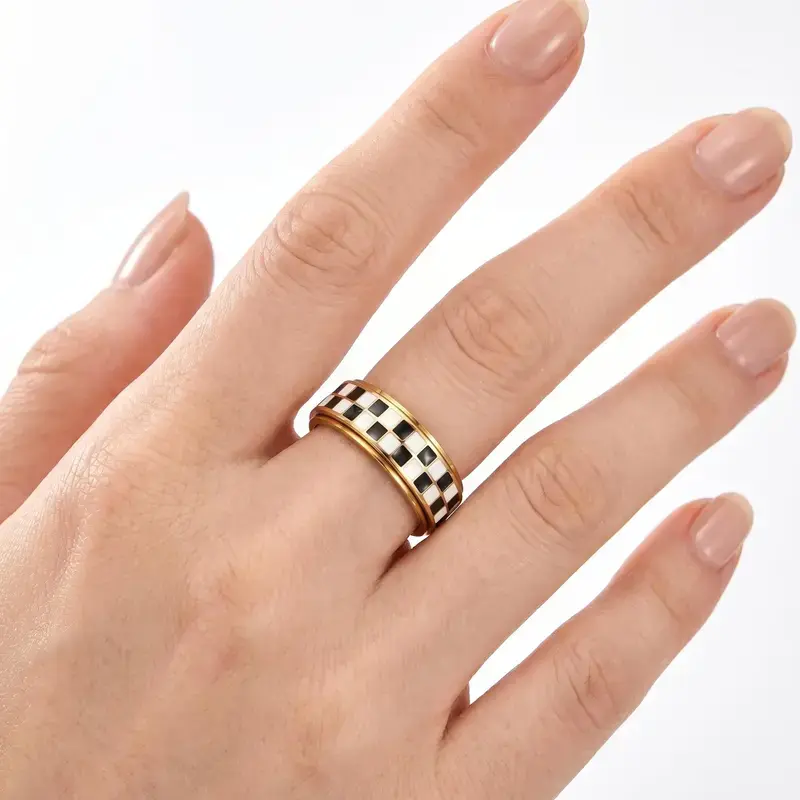 Gold checkerboard spinner ring worn on hand