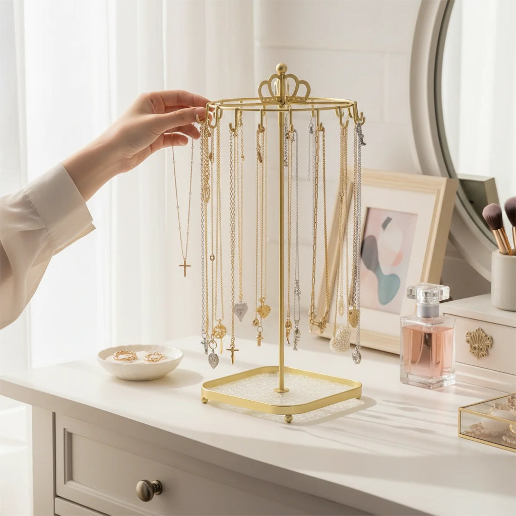 Crown Carousel Jewelry Stand — gold-tone iron necklace stand with glass tray base on a vanity